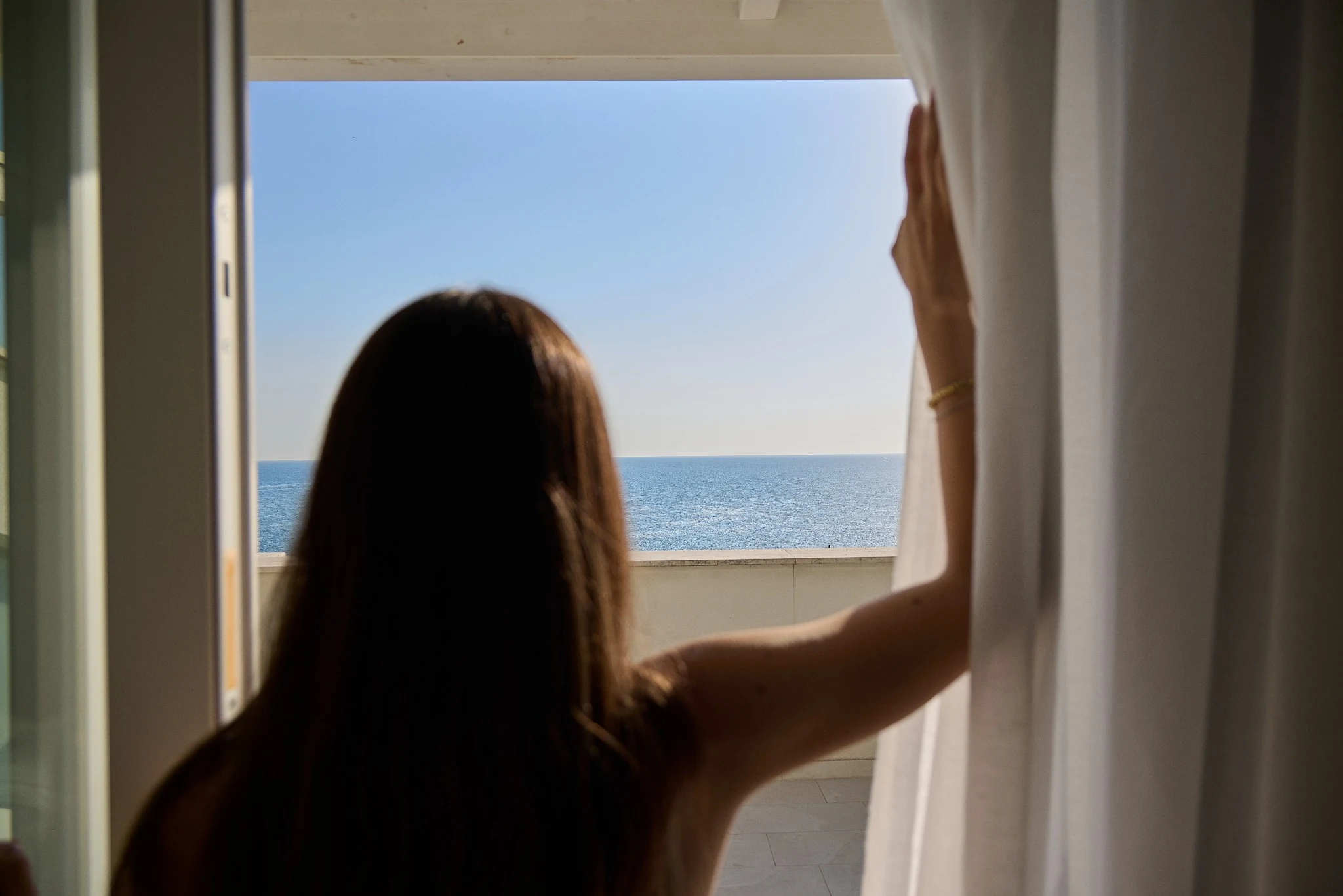 Ospite davanti alla finestra con vista sull'Adriatico